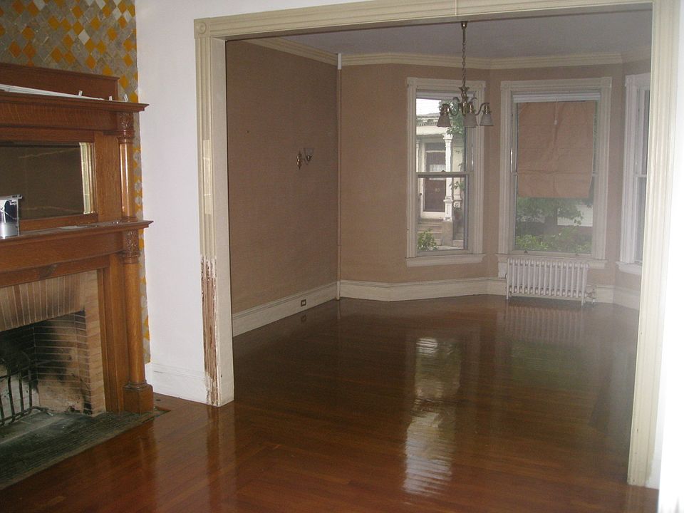 fireplace parlor to living room with bay windows, this room connects to dining room which is divided by pocket doors