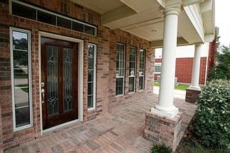 Lovely brick-paved portico enhanced by leaded glass doorway