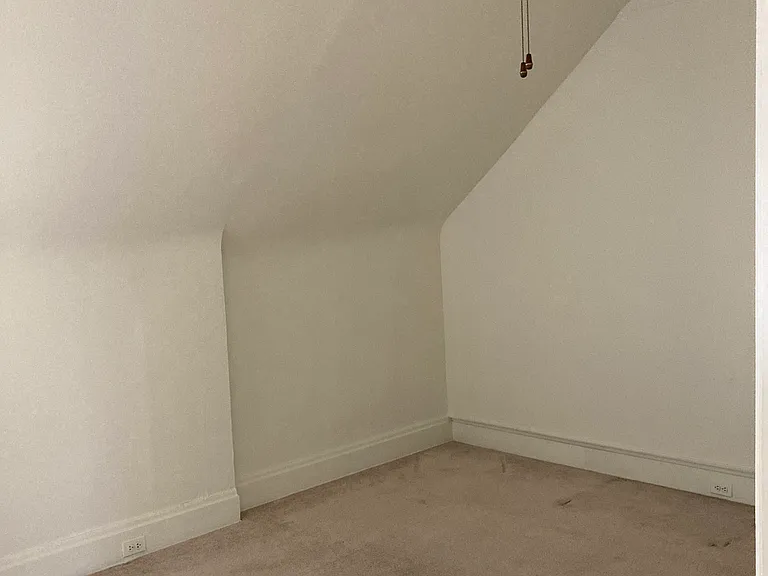Carpeted bedroom with ceiling fan.