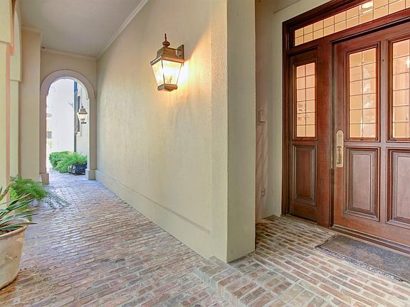 Tons of natural light fill the entrance. The rich mahogany front door is accented by the warm antique brick flooring.