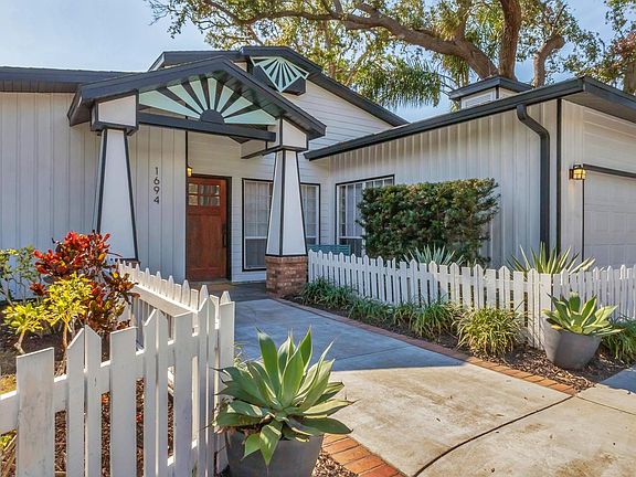 Front of house with bench seating on porch and circular driveway