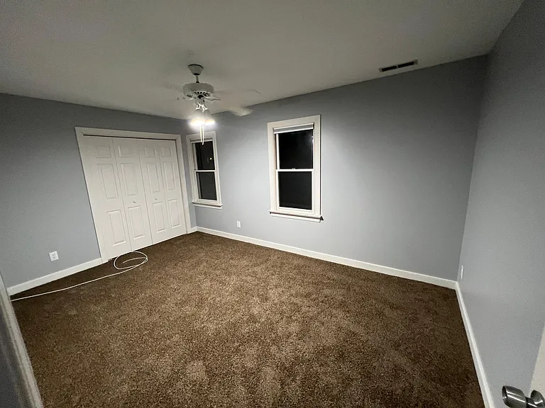 Looking into bedroom 2 from the hallway, windows face the front of the house