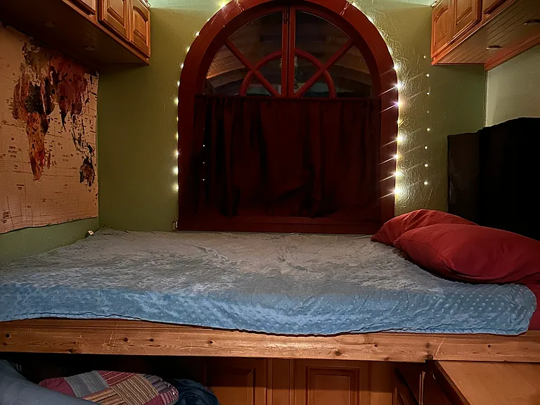 The bed pulled out over the countertop in nighttime mode creates a cozy haven for sleep. Please note that pulling out the bed and climbing up into it requires a moderate level of strength, dexterity, and nimbleness.