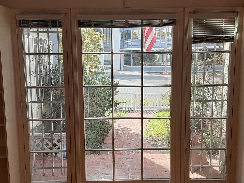 Close Up view of Front Living Room Windows that offer view of Red Brick patio and front Yard entrance.