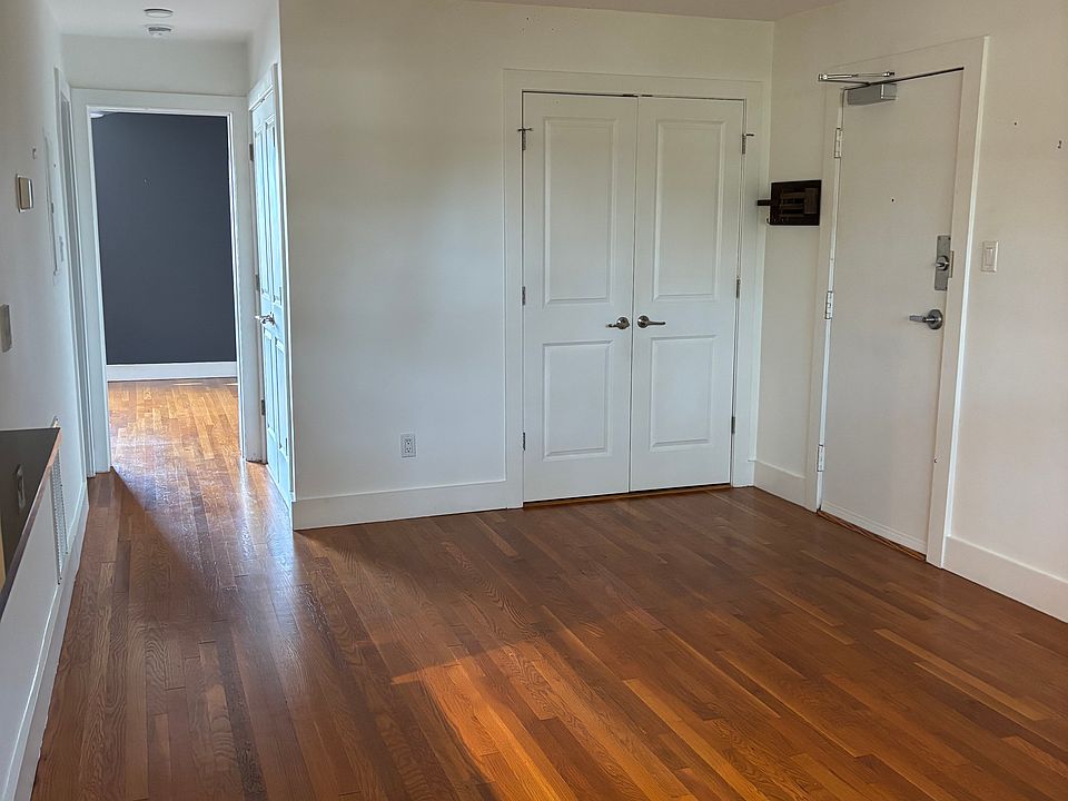 Living room with front door, entry closet, and hallway to bedroom.