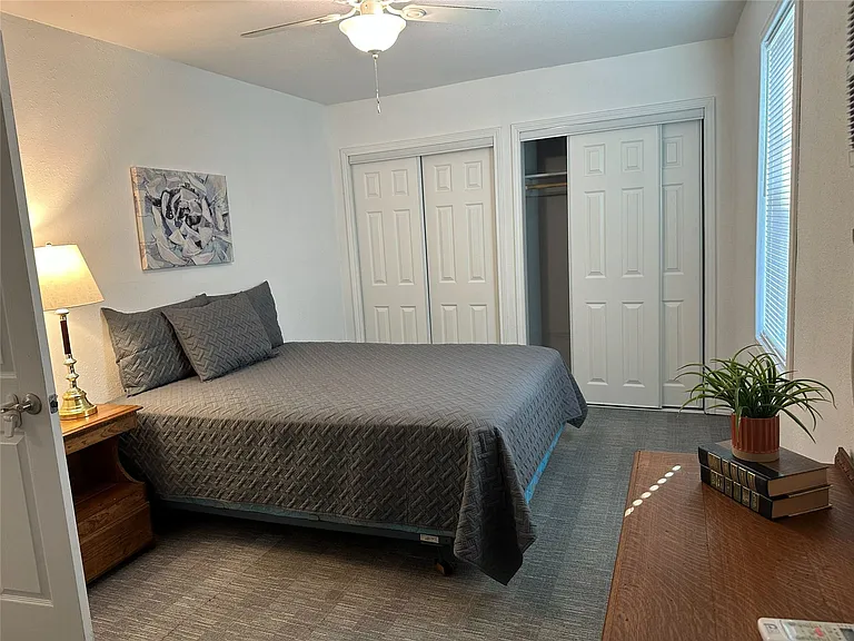 Main bedroom with closets and ceiling fan and access to backyard