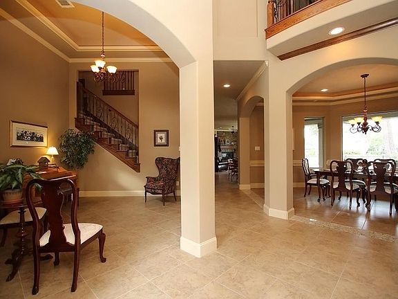 Versatile open floor plan! Entry, Living Room and Dining Room share views of the amazing back yard and golf course beyond. View from the Entry into the Living Room and Dining Room.