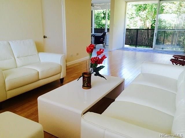 Large open living room, dining, kitchen area looking out to treetops