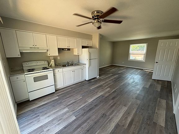 Kitchen with new counters, cabinets, range hood and stove.