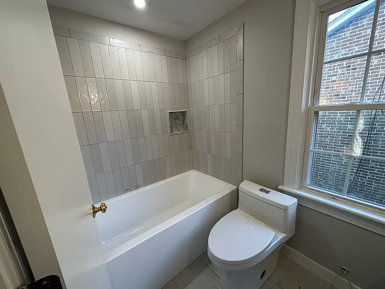 Hall bathroom with 32" tub, tile surround and tile floor. Double vanity, double recessed medicine cabinets. All brand new.