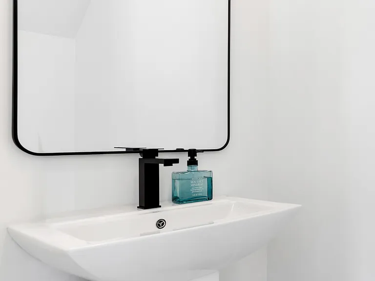 Half-bath, sink, and toilet, downstairs. Cabinet above the toilet.