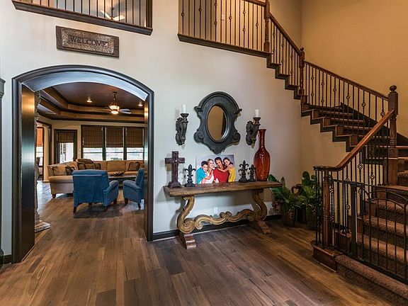 Dramatic two story foyer with wrought iron staircase.