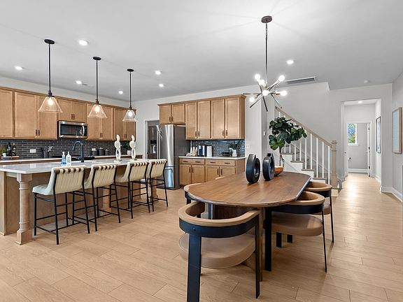Open-Concept dining area and kitchen with premium lighting in the Adaline Plan new townhome by DRB H