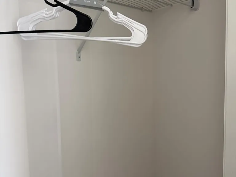 Dedicated closet space with a wire shelf and hanging rod for easy clothing storage and organization.