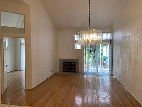 Living Room with vaulted ceiling, fireplace and entrance to large downstairs master suite. Picture taken from kitchen.