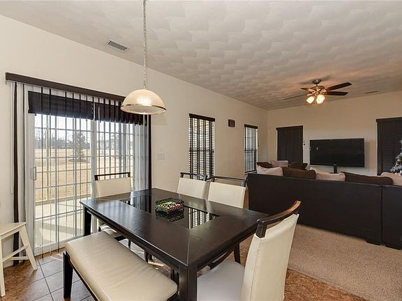 Eat in kitchen area with tiled floors overlooking screened patio and open green space.