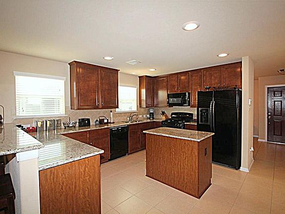 Granite Countertops, black appliances, recessed lighting and tile backsplash