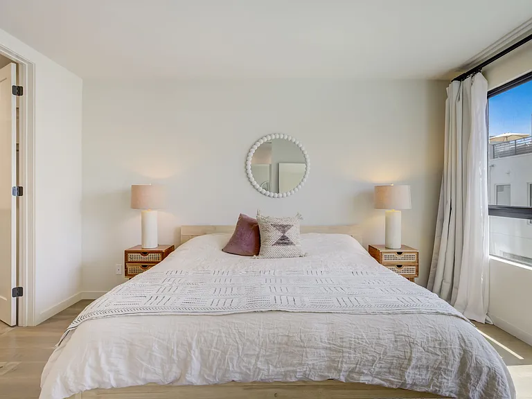 Spacious primary bedroom shown with a king-size bed, offering plenty of room for additional furniture and seating.