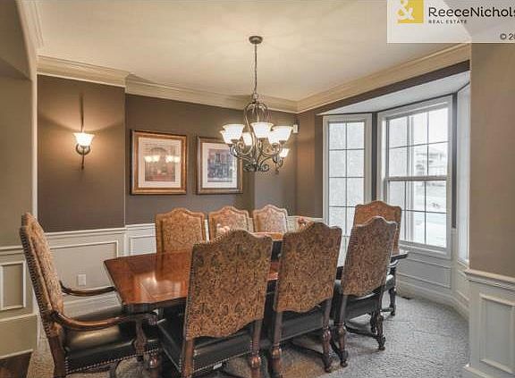 Dining room w sconce lighting off foyer and attached to kitchen