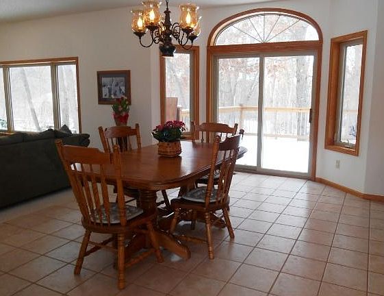 Dining room with ceramic floor and bay walk out to the maintenance free deck over looking your woode