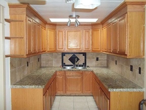 Nicely finished kitchen with granite tile countertops