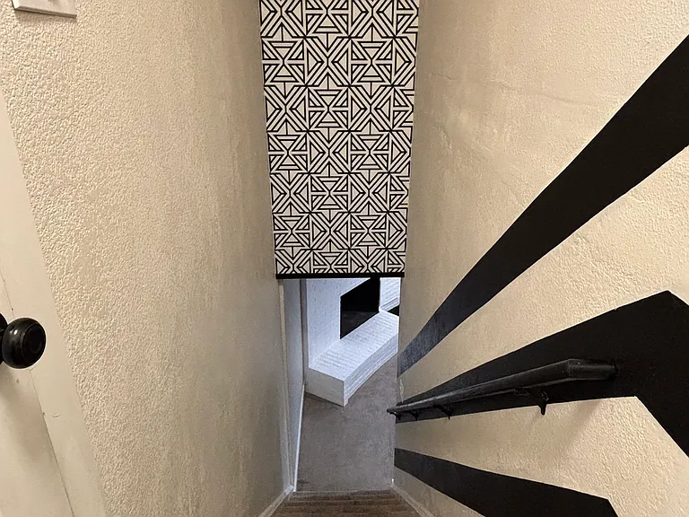 Stairs and railing leading to the unit with modern decor