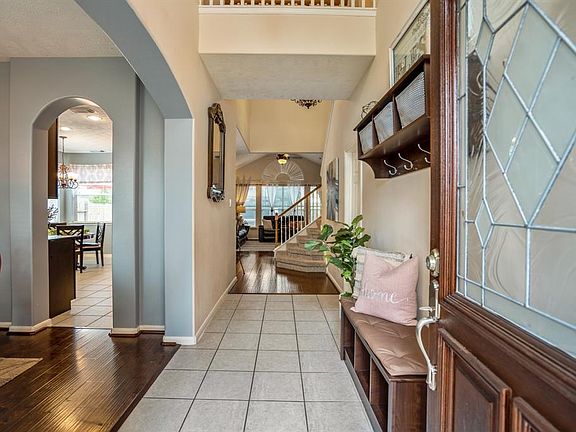 WHAT AN ENTRANCE! The high ceiling of the front porch continues through the entryway bringing in that open and grand feel. Already we can see the gorgeous neutral tile & laminate wood flooring found throughout the first floor. Pictured to the right i