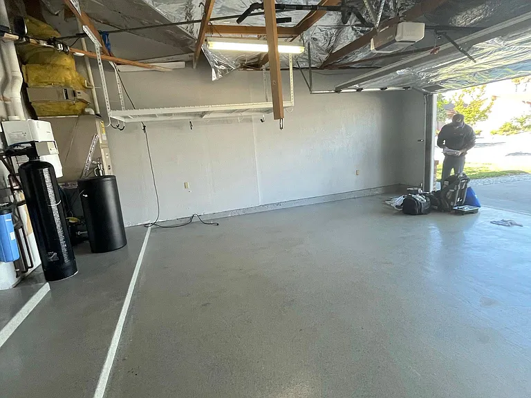Finished & insulated garage with epoxy floor and overhead storage racks.