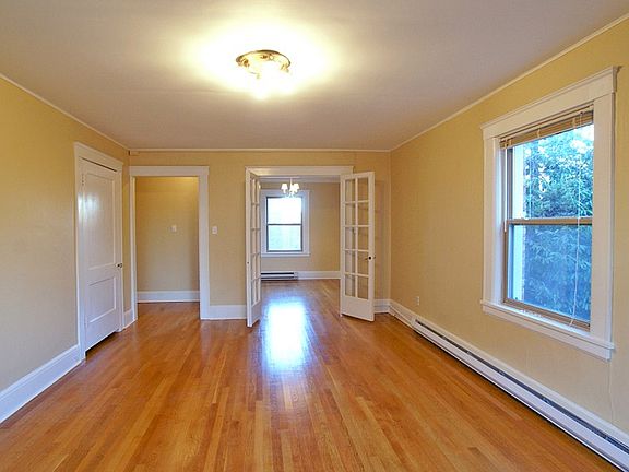 Large bright corner living room with hardwood floors, high ceilings, plenty of light