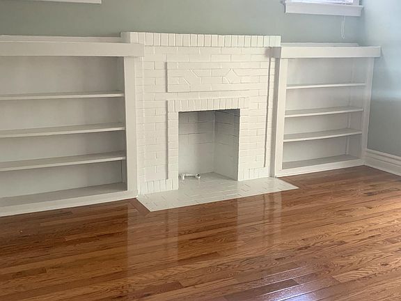 Built in shelved and faux fireplace in primary bdrm