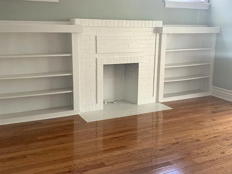 Built in shelved and faux fireplace in primary bdrm