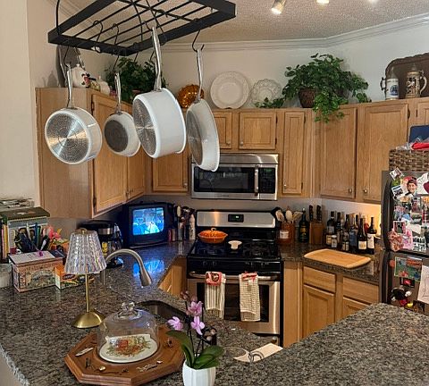 The kitchen features a gas oven, full size fridge, dishwasher, microwave, hanging post. A plethora of cabinets for storage and a large pantry closet.
