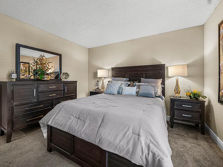 Comfortable bedroom with plush carpeting and neutral finishes.
