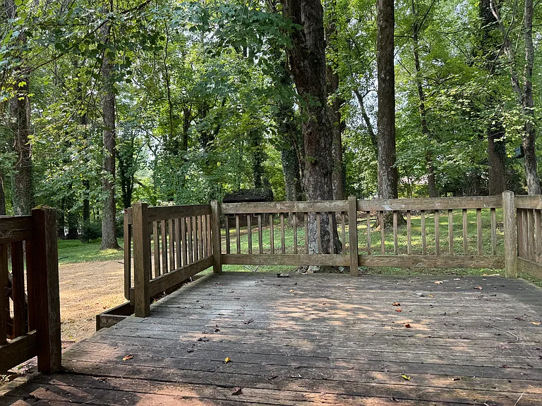 Deck off back of carport. Leads to backyard.