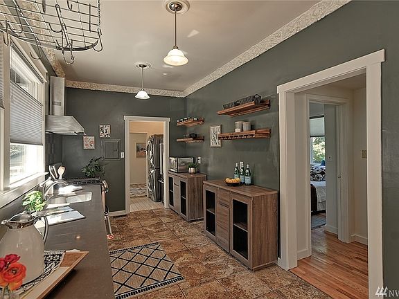 Updated kitchen with tile floors and stainless steel applinaces, modern lighting and decorative crown molding. 