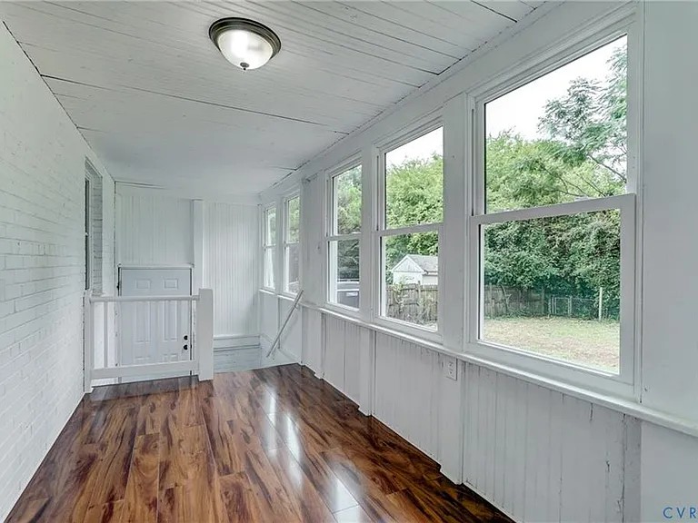 Bright Florida room with steps leading to the landing for the door to the backyard and additional set of steps to the basement.