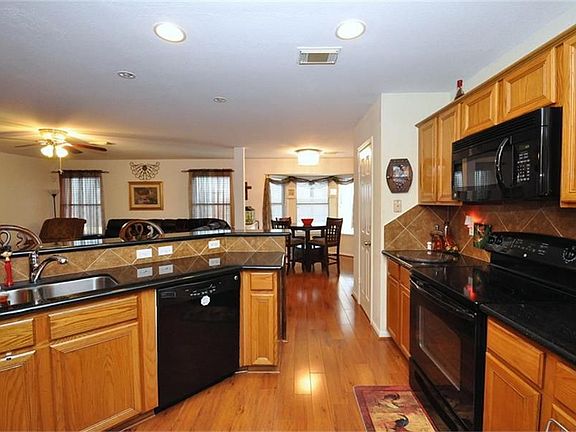 Kitchen displays granite counter tops with Black appliances. All appliances stay.