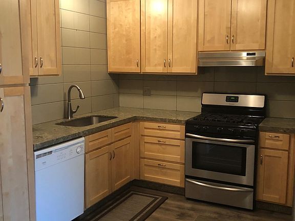 Beautiful kitchen has new wood cabinets, granite counters, farm sink, wood laminate floors. New stove and refrigerator.
