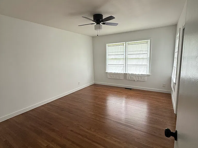 Comfortable bedroom with hardwood floors and plenty of closet storage.