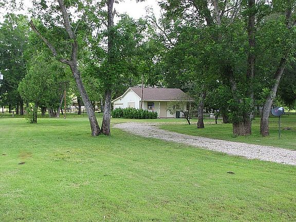 A VIEW FROM THE STREET OF THE DRIVEWAY AND SHOP