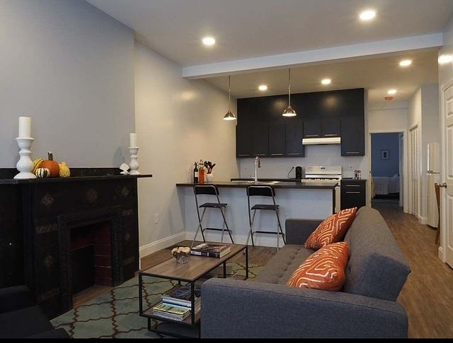 Step inside the private entrance to a spacious and open living/dining/kitchen area. Highlight includes a stunning black, marble fireplace mantel in the living room. Fireplace is non-working.