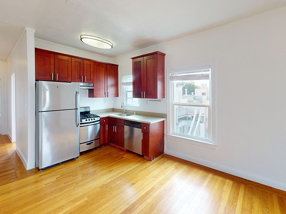 Living room with a window, wood-like flooring, and a view of the kitchen