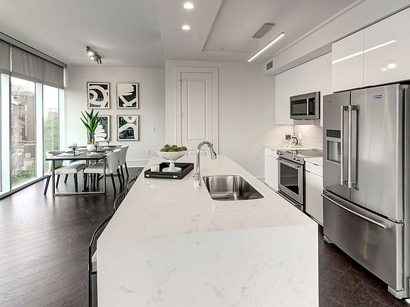 Gourmet Kitchen with Stainless Steel Appliances and Premium Quartz Waterfall Countertops