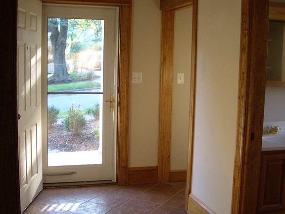 Front foyer looking out front door, hall closet and bath wit