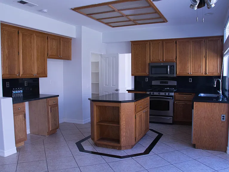 Kitchen with plenty of storage space, granite top covered island, and counter tops. Oven and stove, microwave, and dishwasher.