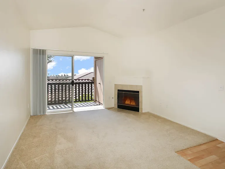 Carpeted Living Room with FIreplace and Balcony