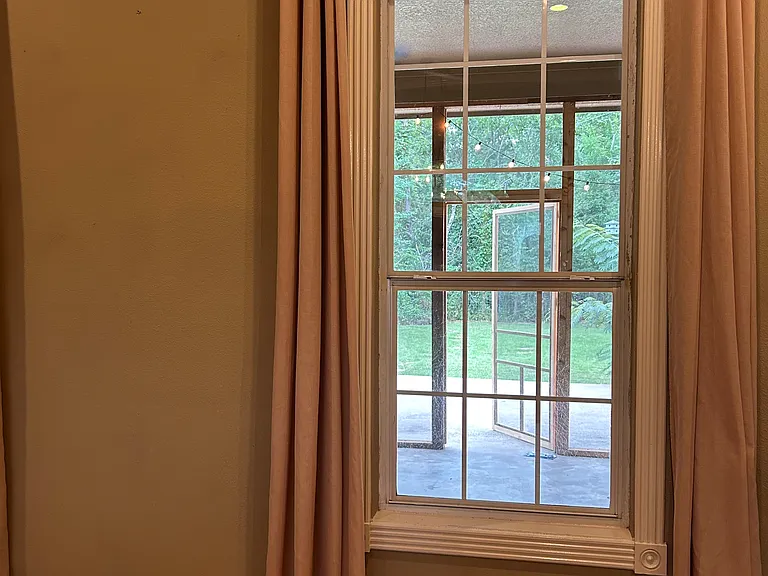 view from living room into screened room and backyard