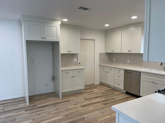 View from kitchen entrance next to living room with refrigerator hookup.