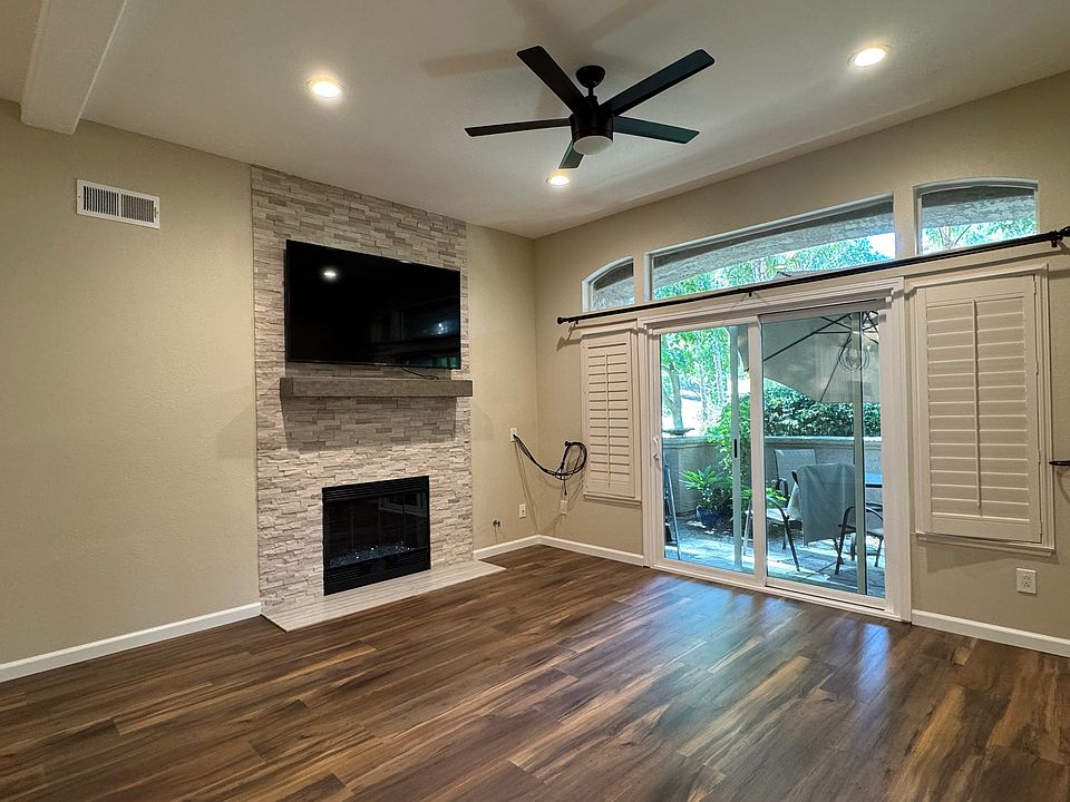 View of the living room and the back patio with the view of green area, that connects to mission trails.