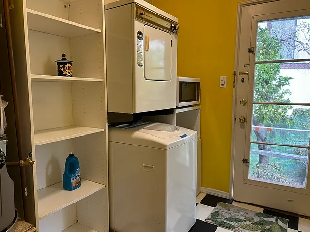 Private laundry and storage area leads to back door with steps leading out to the large enclosed backyard.
